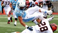 A football player being tacked by an opposing team's player.
